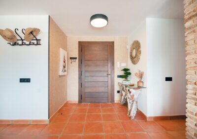 Entrada de la villa con suelo de terracota y mobiliario moderno
