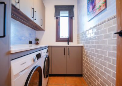 Cuarto de la colada moderno con lavadora, secadora y suelo de terracota