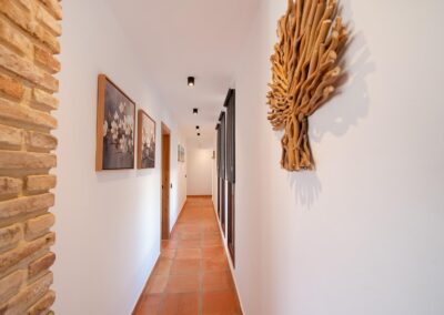 Pasillo hacia las habitaciones con pisos de terracota y decoraciones de lujo y exclusivas