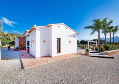 Fachada de la villa con acceso a la piscina y de fondo las montañas de Bernia