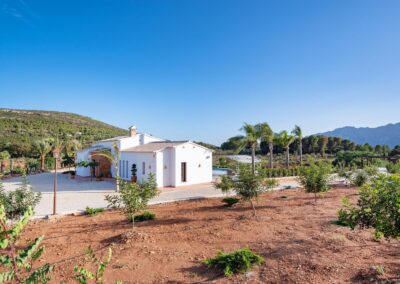 Villa blanca de estilo mediterráneo en un paisaje rural y montañoso